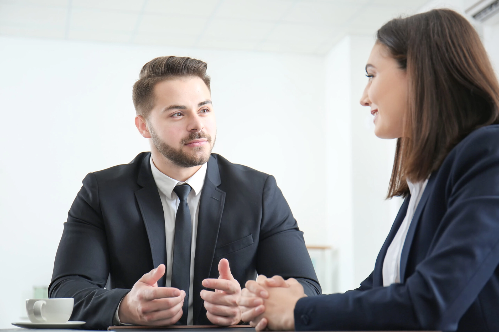 A male and female corporate worker having a discussion over coffee.